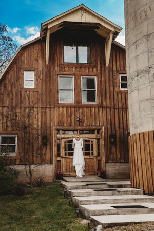 A rustic wooden barn venue with concrete steps and white doors captured in a series of similar angles on a sunny day.