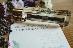 Wedding stationery with rings and perfume bottle for Courtney Umstot and Nicholas Stole at The Barns of Kanak.