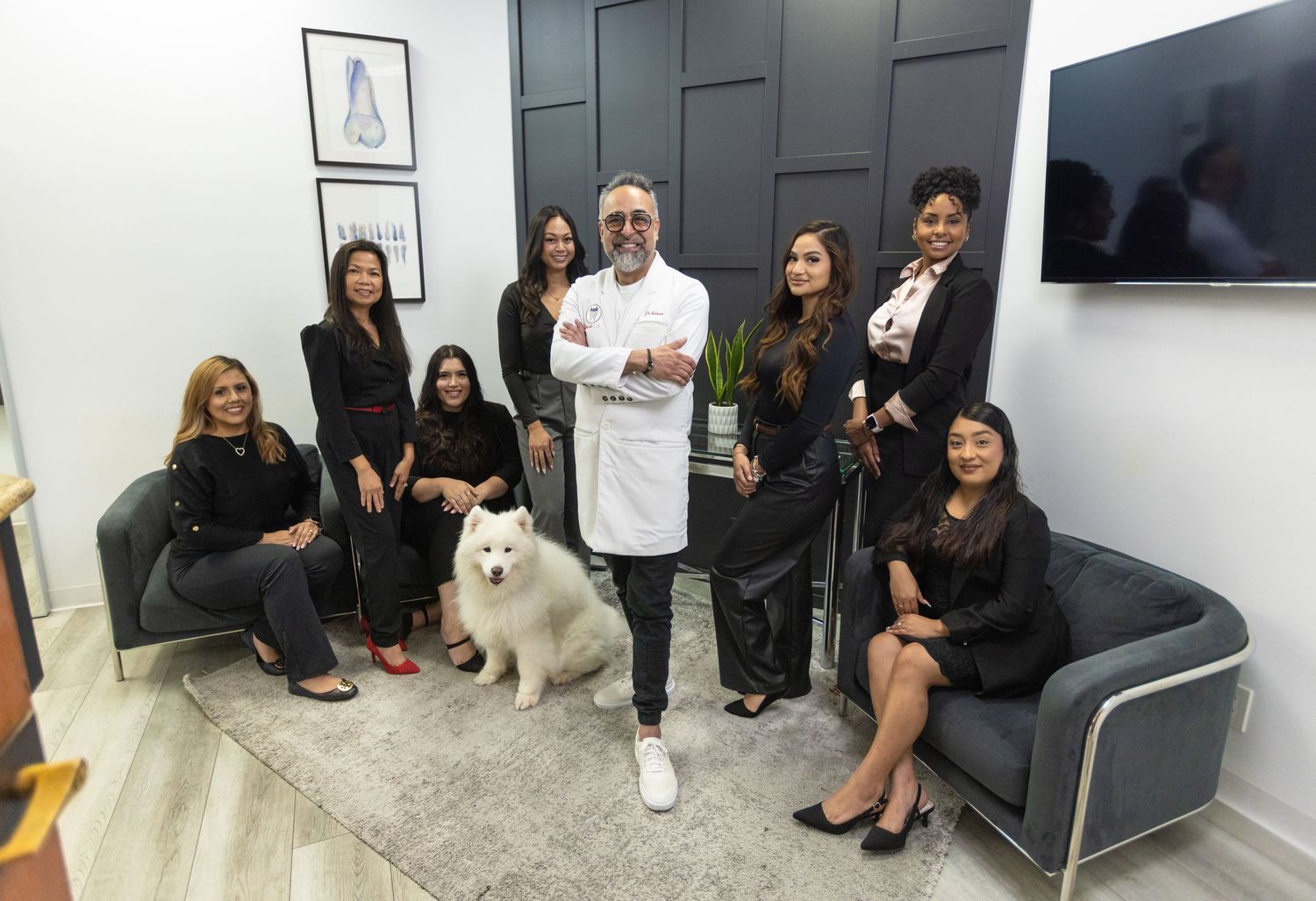 Medical team and white dog posing in modern office waiting area.