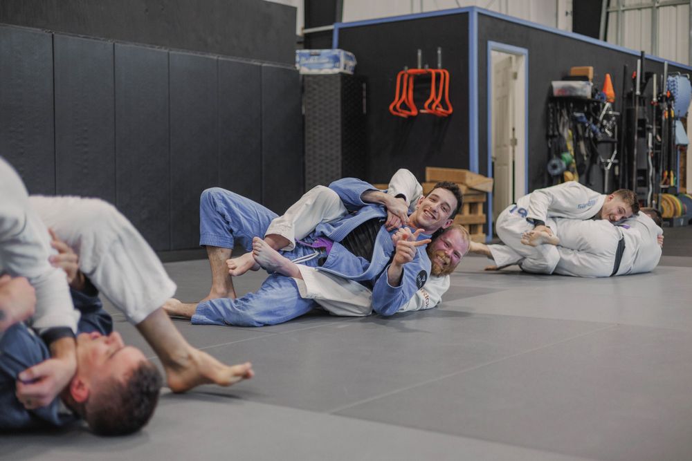 Multiple students practicing ground techniques during a grappling class at Virtuous gym.
