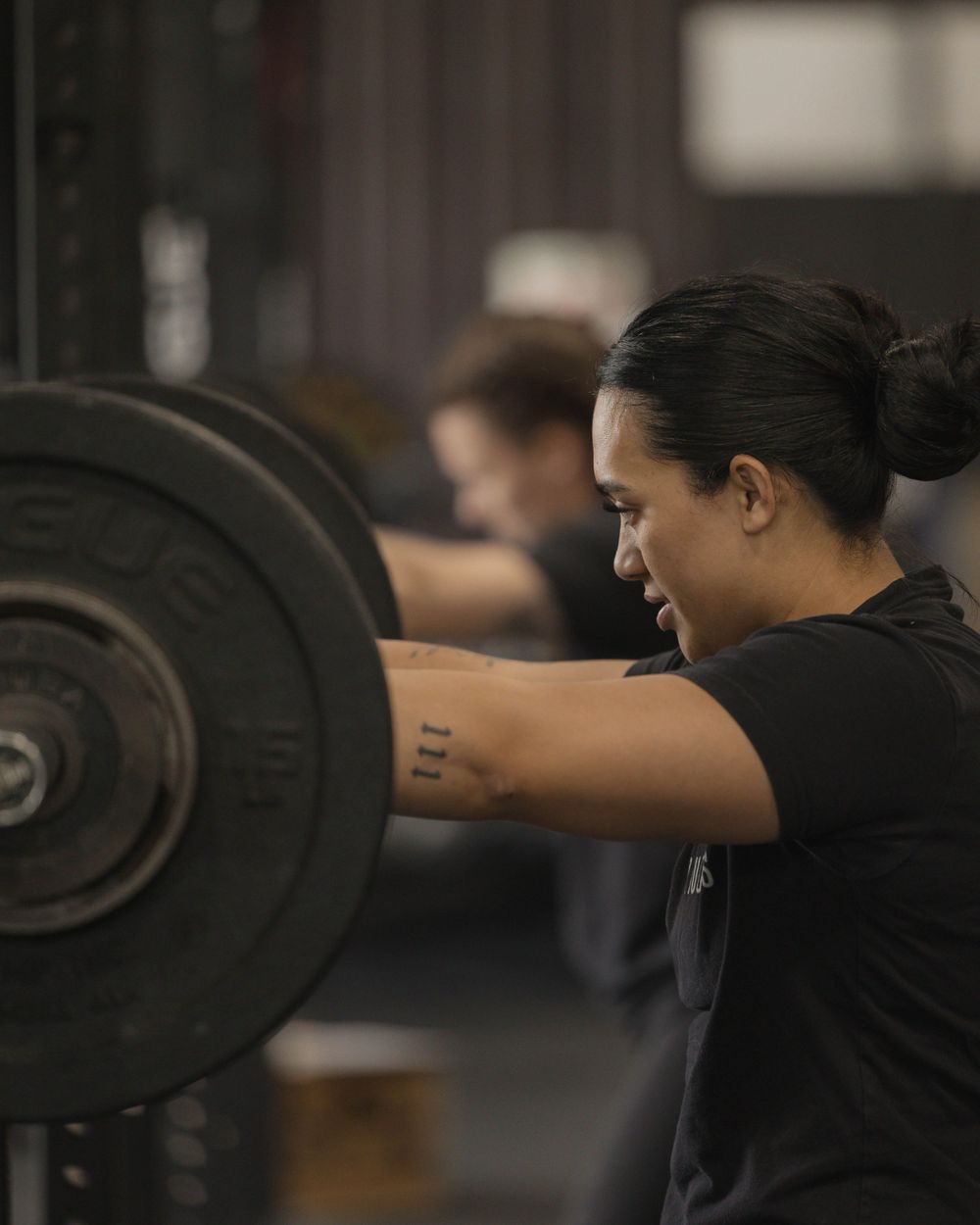 Athlete lifting weights during strength training session in gym setting.