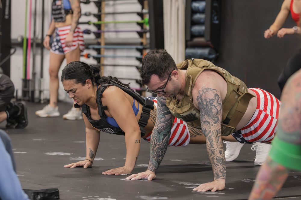 Athletes performing pushups during an intense group workout session.