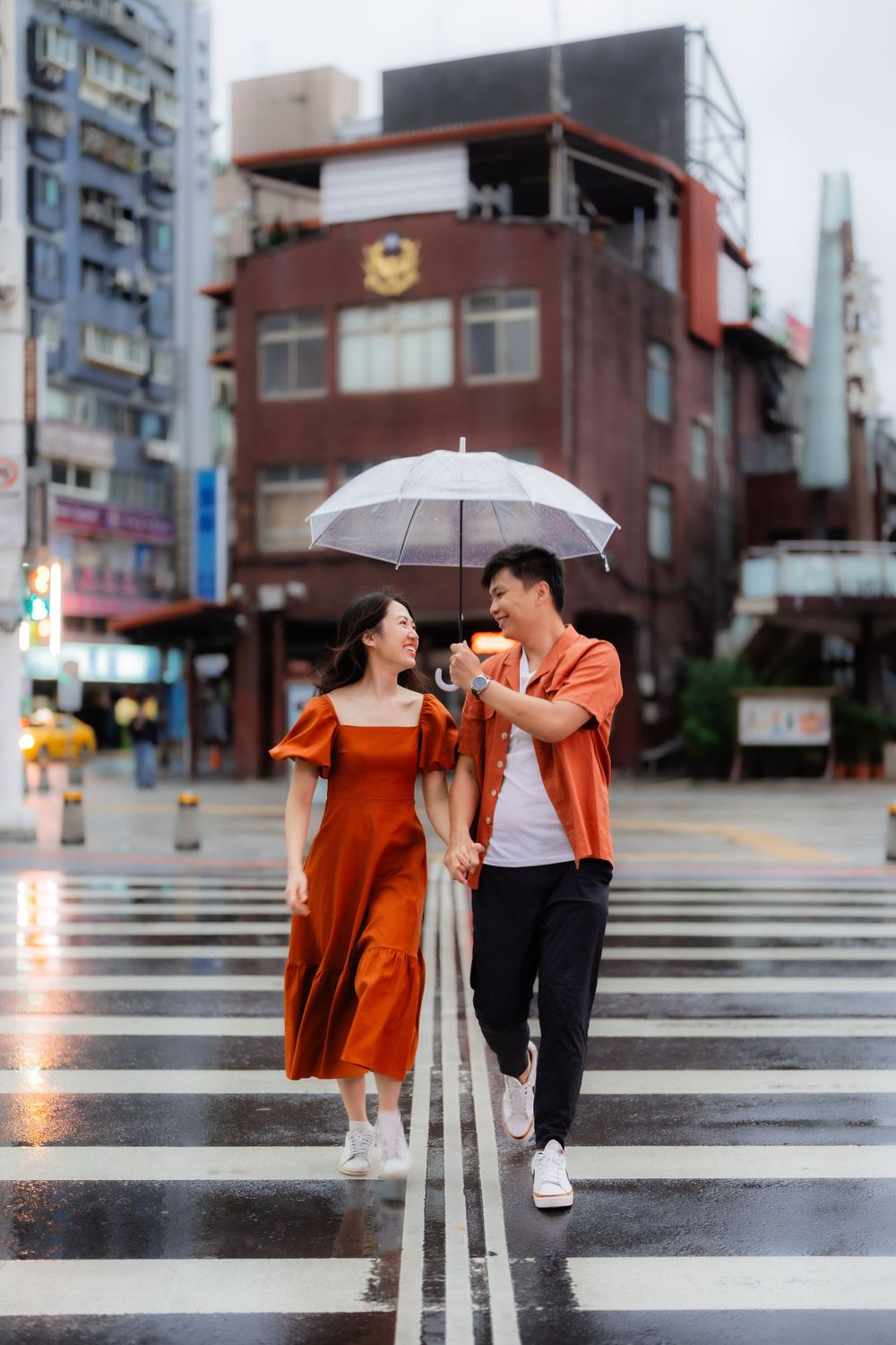 a couple with umbrella crossing the road in Ximending