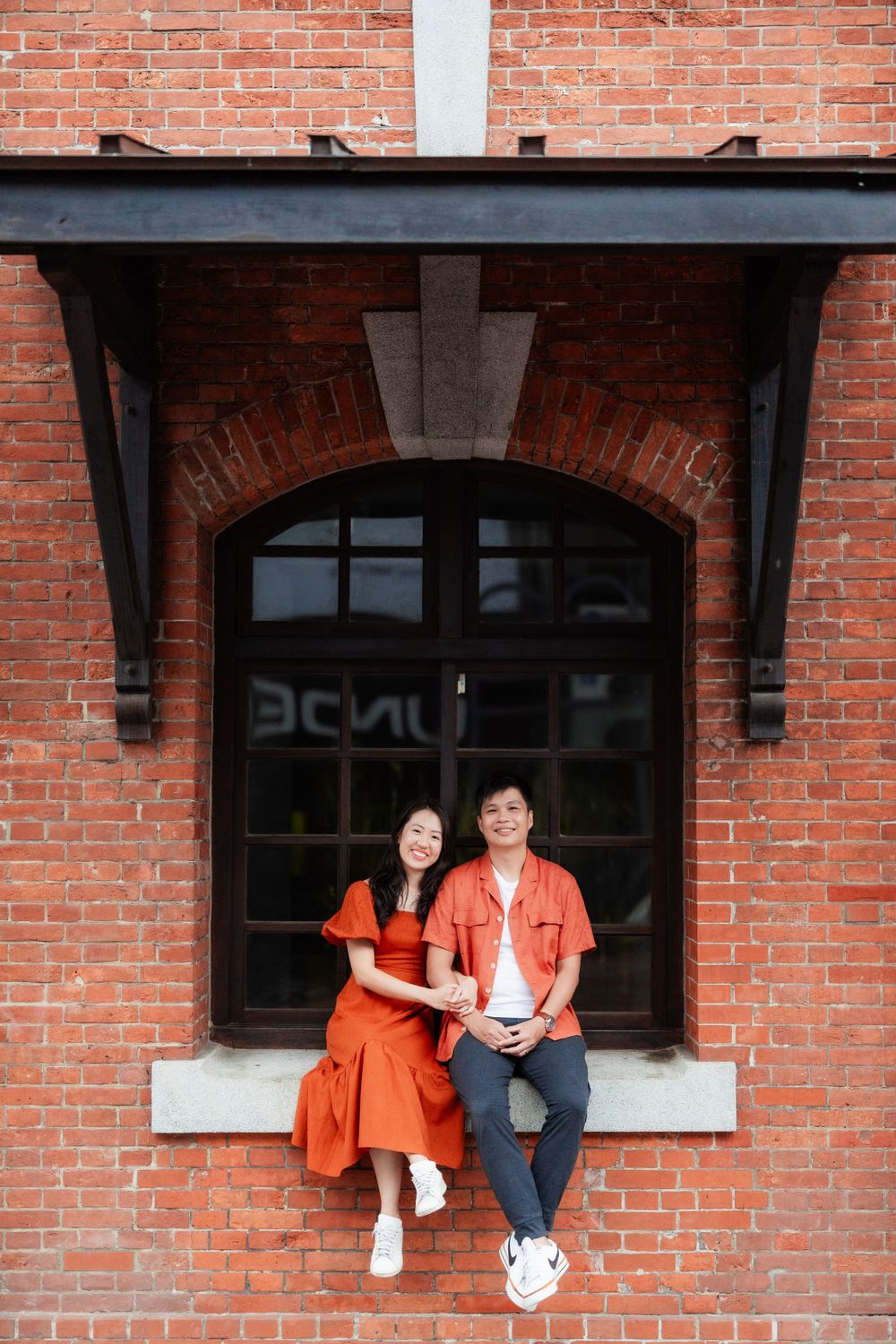 a couple sitting on the brick building in Ximen