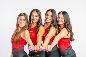A group of people wearing red shirts pose together in a casual photo session.