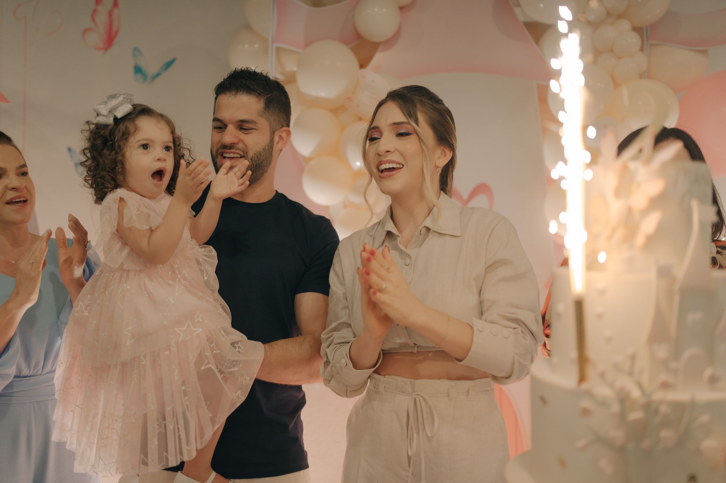 Festive family party scene with sparklers and pink decorations.