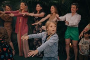 Group of people dancing with arms outstretched at lively party.