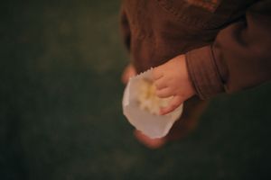Close-up shot of hands holding in a dimly lit setting.