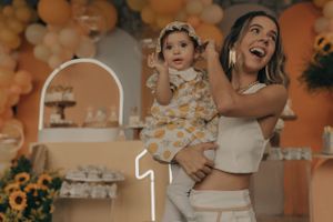 A celebratory moment against an orange balloon arch with sunflower decorations.