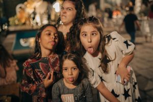 Group making silly faces together during outdoor celebration.