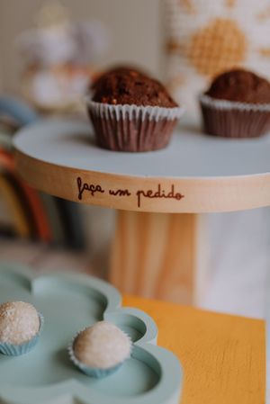 Chocolate cupcakes and white truffles displayed on tiered dessert stands at party.