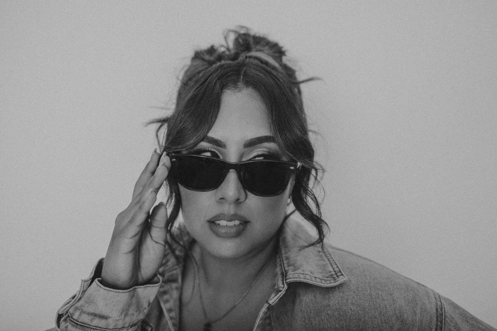 Vintage style portrait with sunglasses and denim jacket.