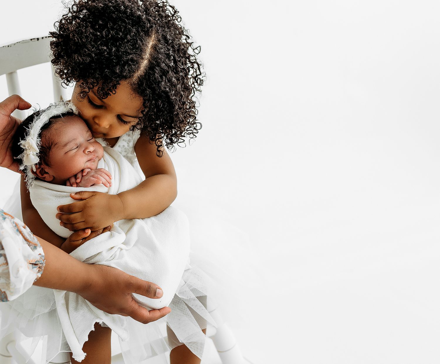 An intimate black and white portrait of a parent cradling and bonding with their newborn.