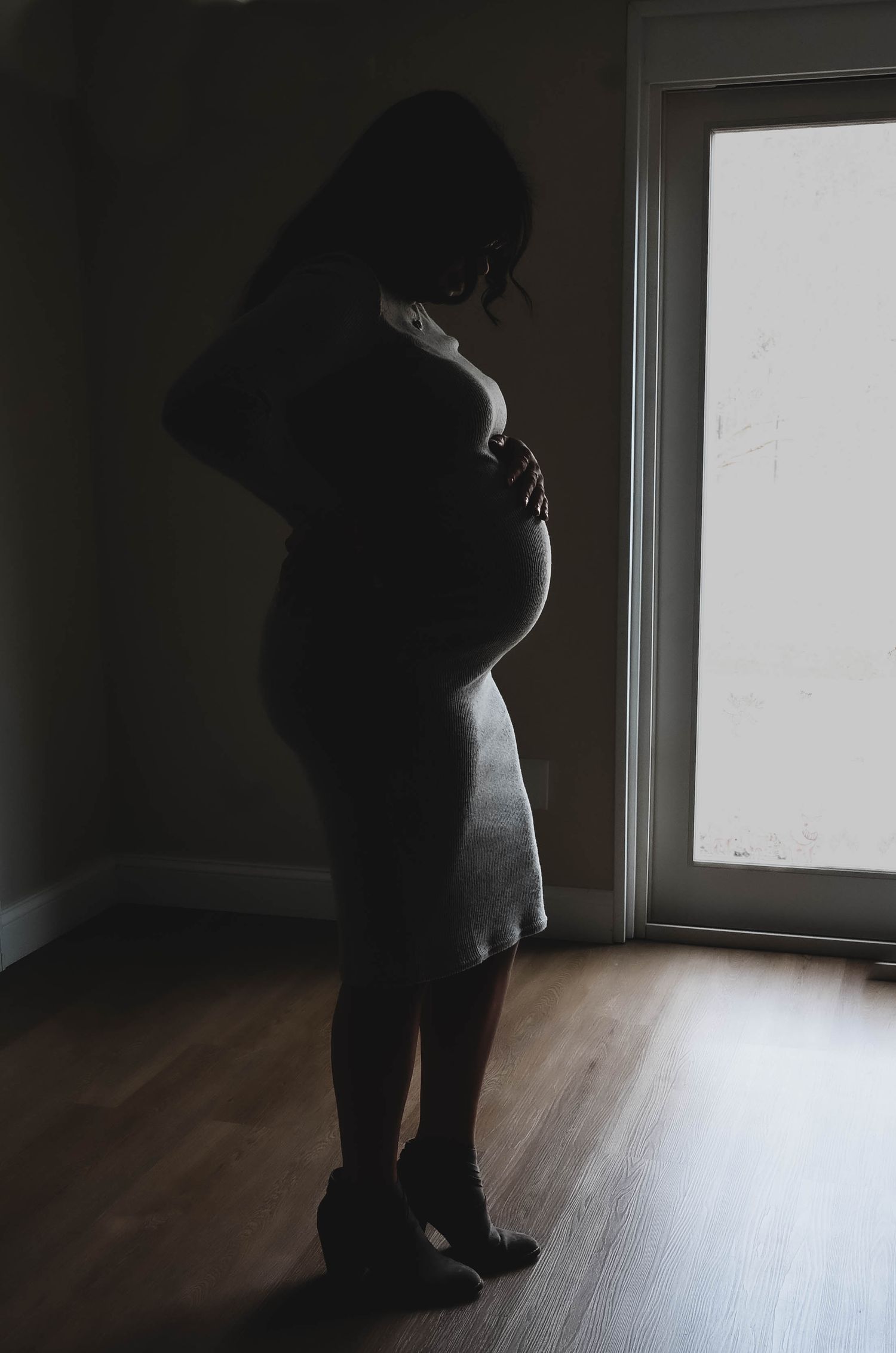 In home lifestyle maternity portrait session silhouette of mom in Albany NY