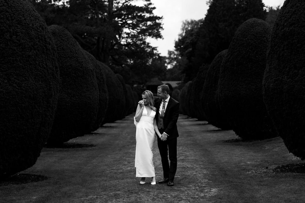 A black and white wedding photo sequence shows a couple walking down a tree-lined path together. Elvetham Hotel