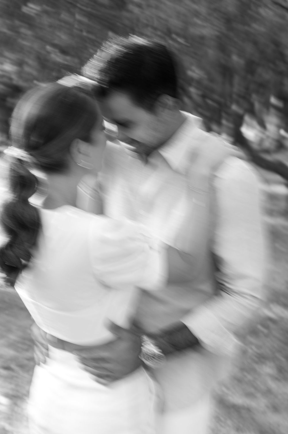 A blurred black and white motion shot of a couple dancing together.