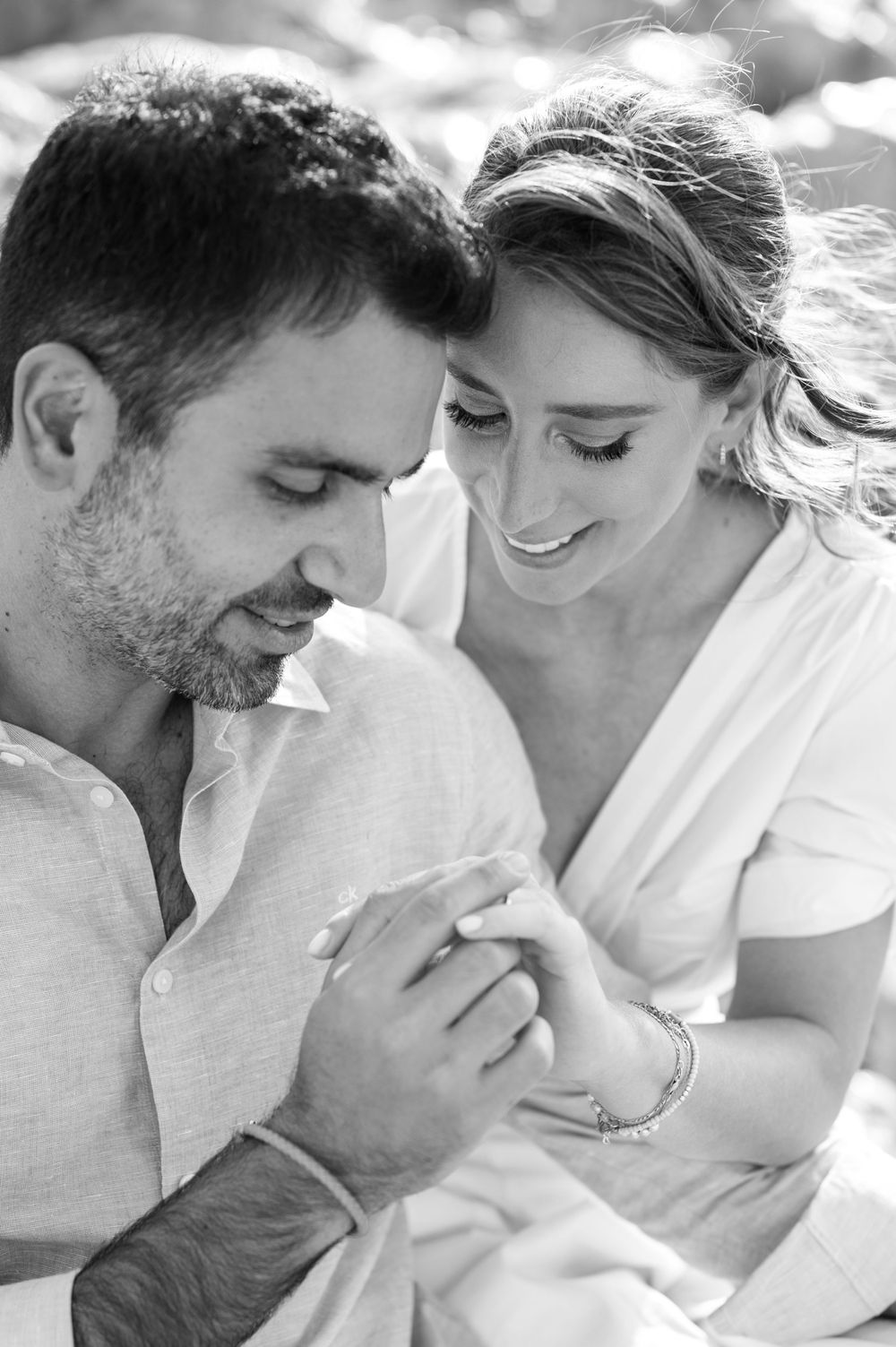 Intimate black and white portrait of couple sharing tender moment outdoors.