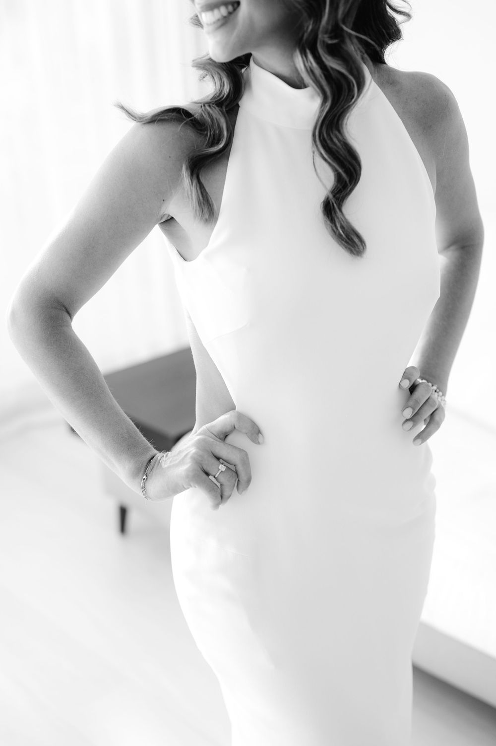Elegant black and white closeup of a white halter neck dress with wavy hair details.