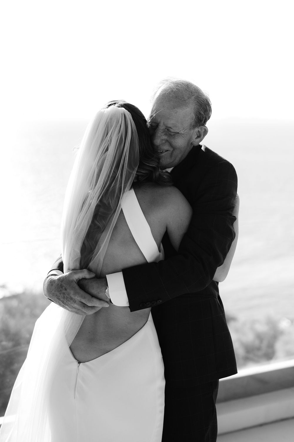 Black and white emotional moment of an embrace during a wedding ceremony.