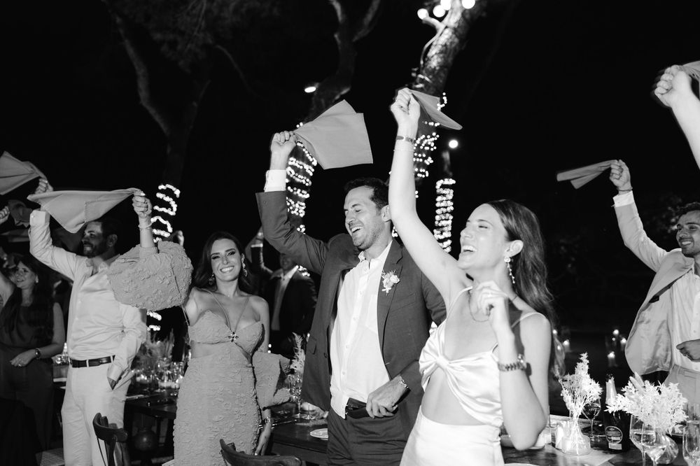 Black and white photo of wedding celebration with guests dancing at night.
