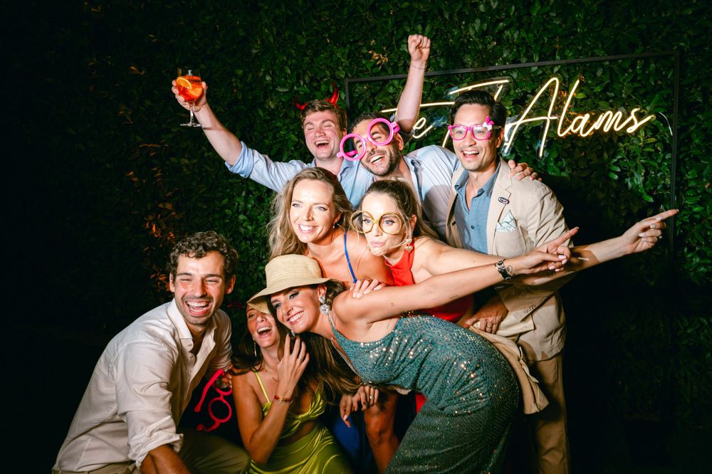 Group poses energetically for a fun nighttime photo with decorative lighting.