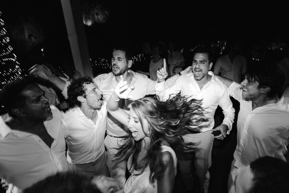 Energetic black and white photo of party guests dancing and celebrating.