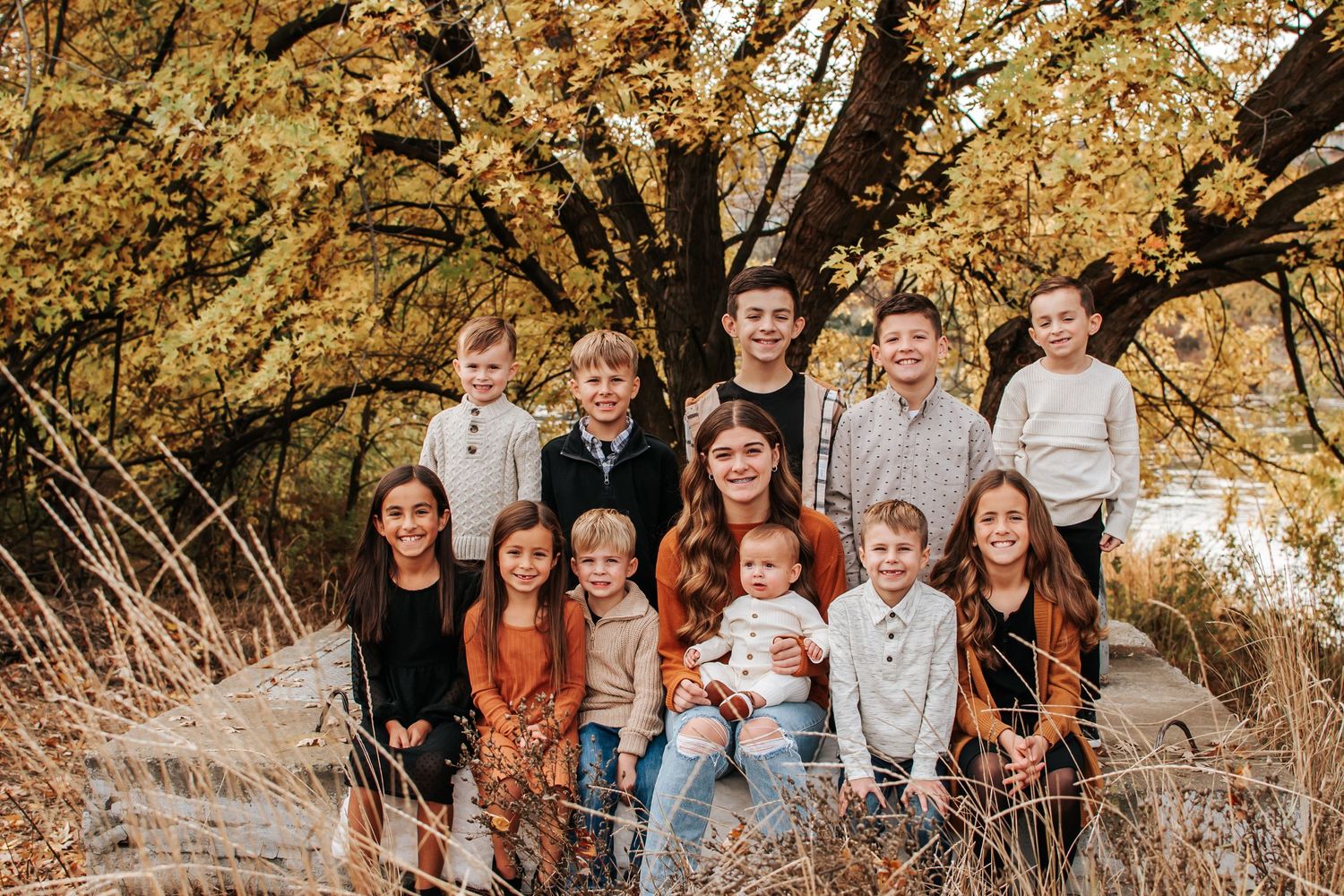 Extended family gathering under golden fall trees for outdoor portrait session in Richland, Washington