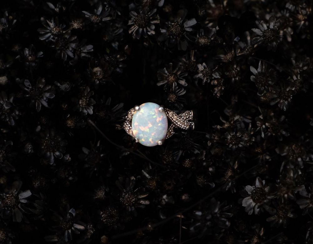 Abstract dark background with delicate floral patterns and subtle lighting effects.