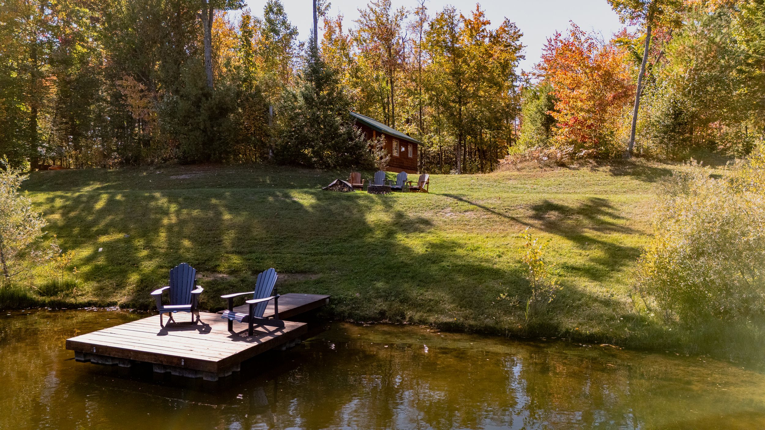 Lakefront view of a cottage at Domaine Labrador, Ontario, with a deck and chairs overlooking the water.