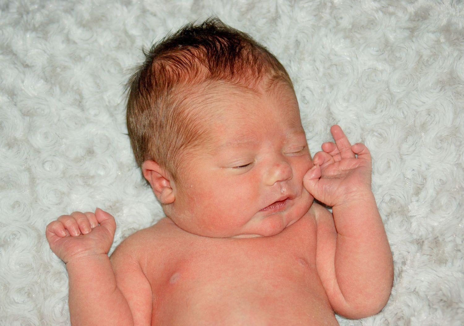 Peaceful sleeping newborn on soft white blanket