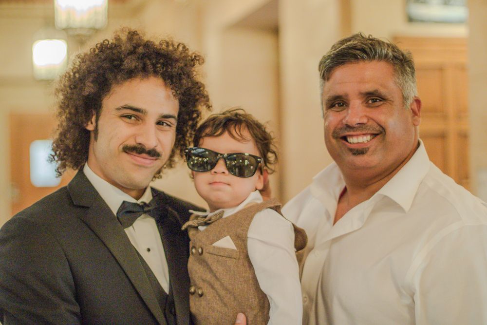 Stylish formal family photo with black bow tie and sunglasses indoors.