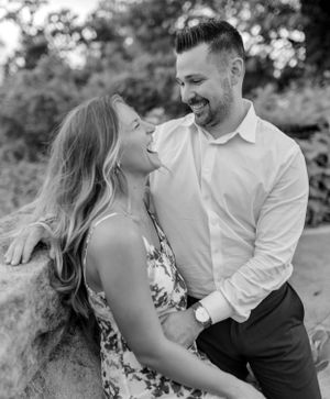 A romantic black and white portrait of a couple sharing a joyful moment outdoors.
