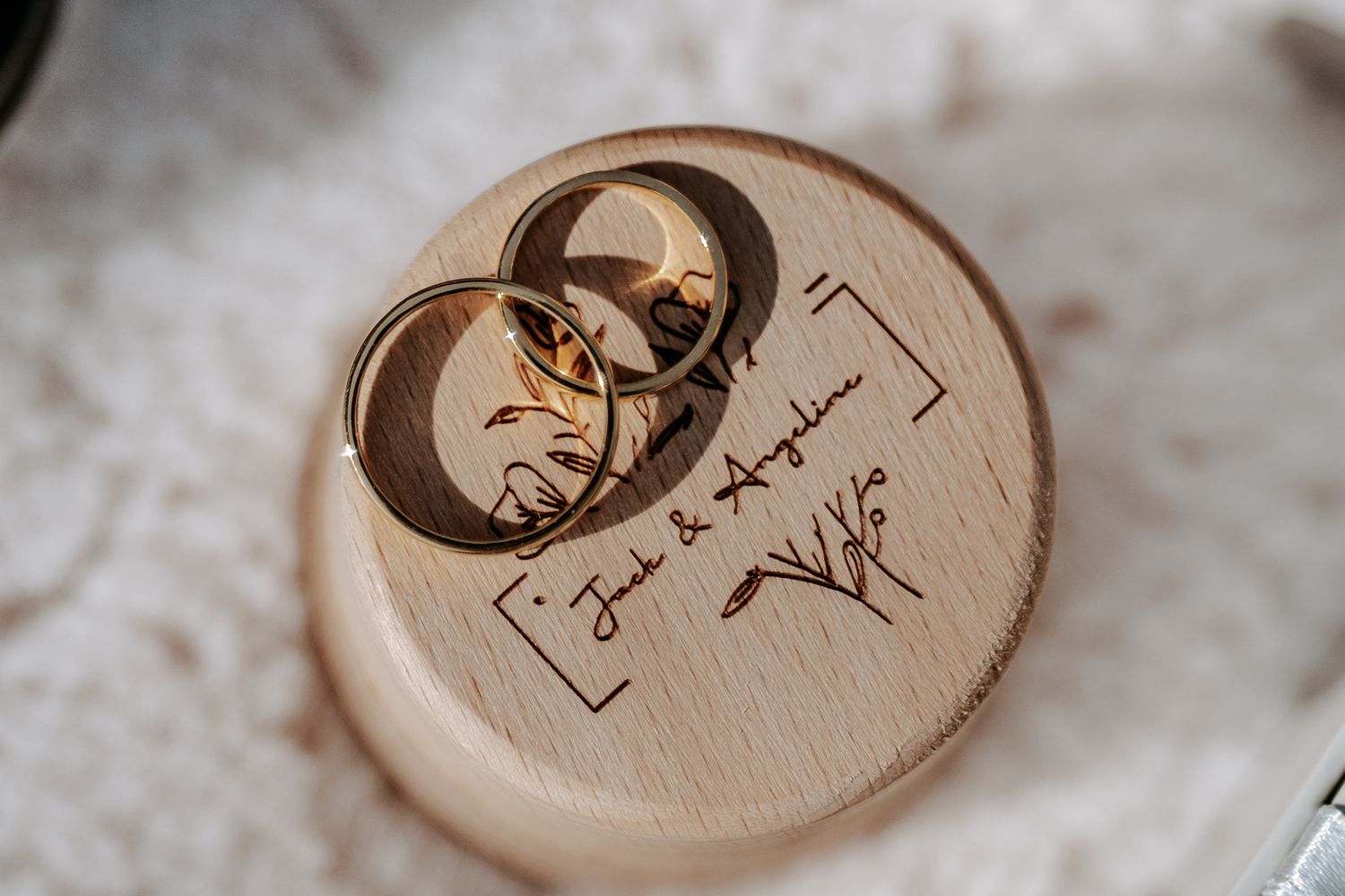 Wooden ring box with custom engraving for holding wedding bands.