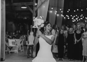 Black and white photo of a wedding reception dance floor with twinkling lights overhead.