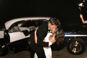 Dark silhouettes of wedding party celebrating at nighttime reception.