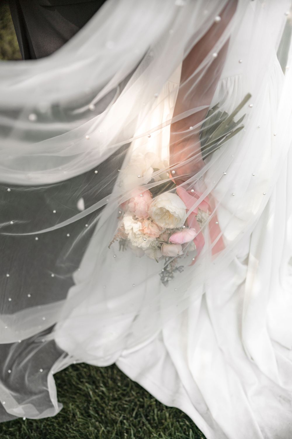Close-up of delicate white lily petals with soft pink undertones in natural lighting.
