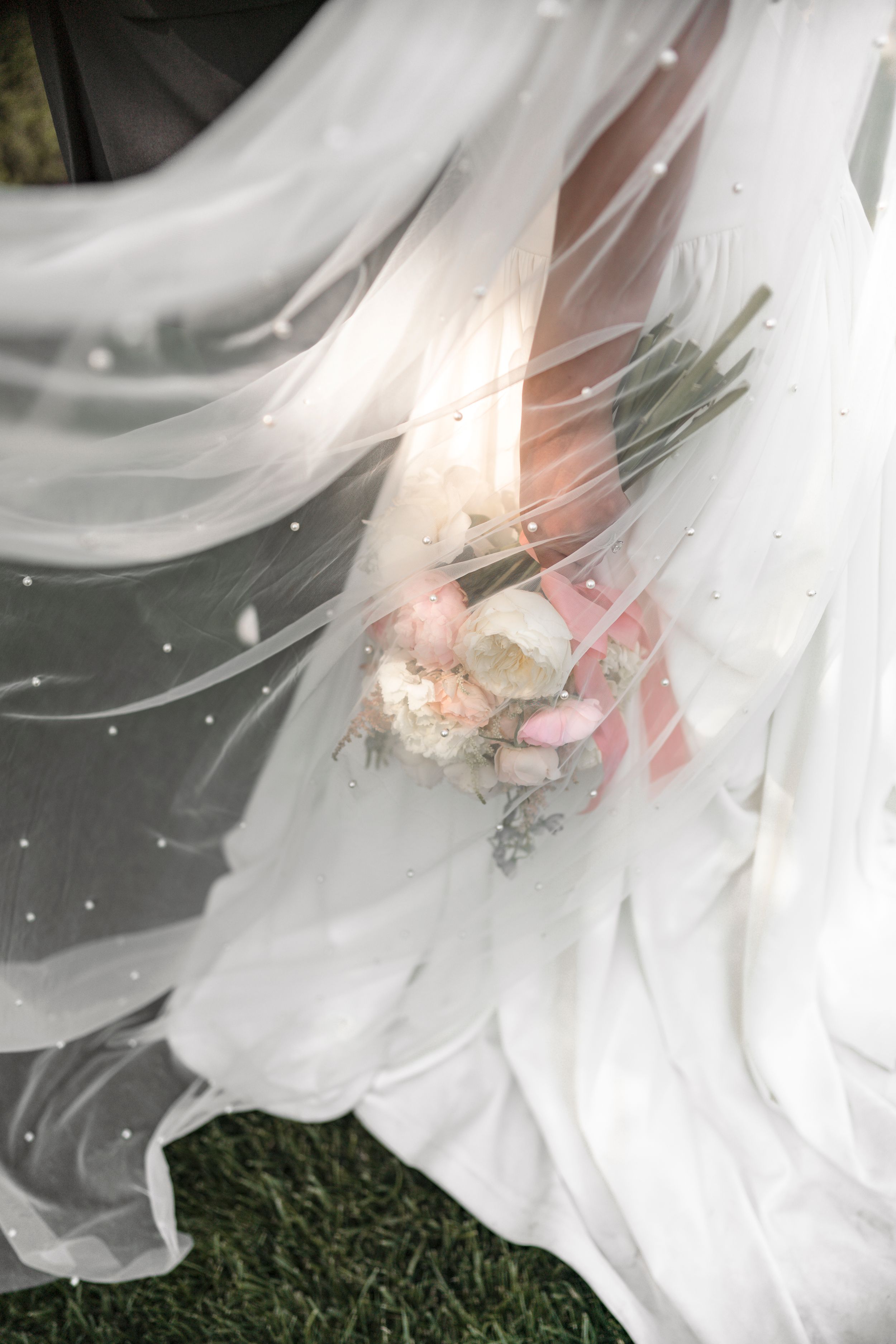 Close-up of delicate white lily petals with soft pink undertones in natural lighting.