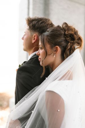 Wedding guests seated during ceremony with white veil in foreground.