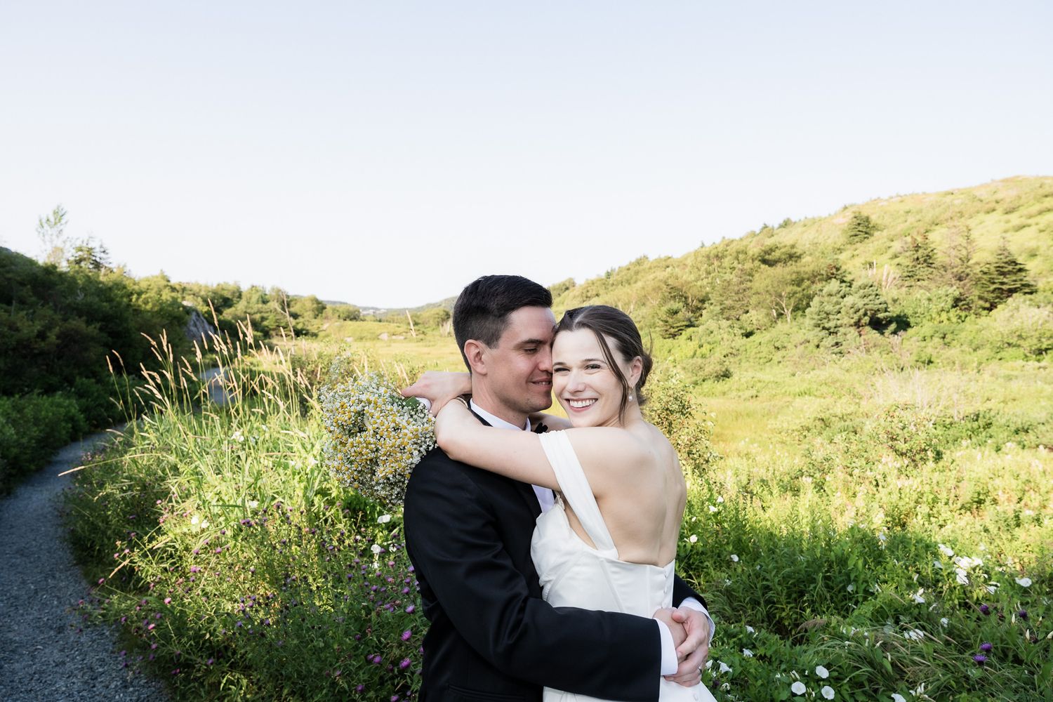 bride hug groom in the green field taken at Alex and Janelle wedding st john's