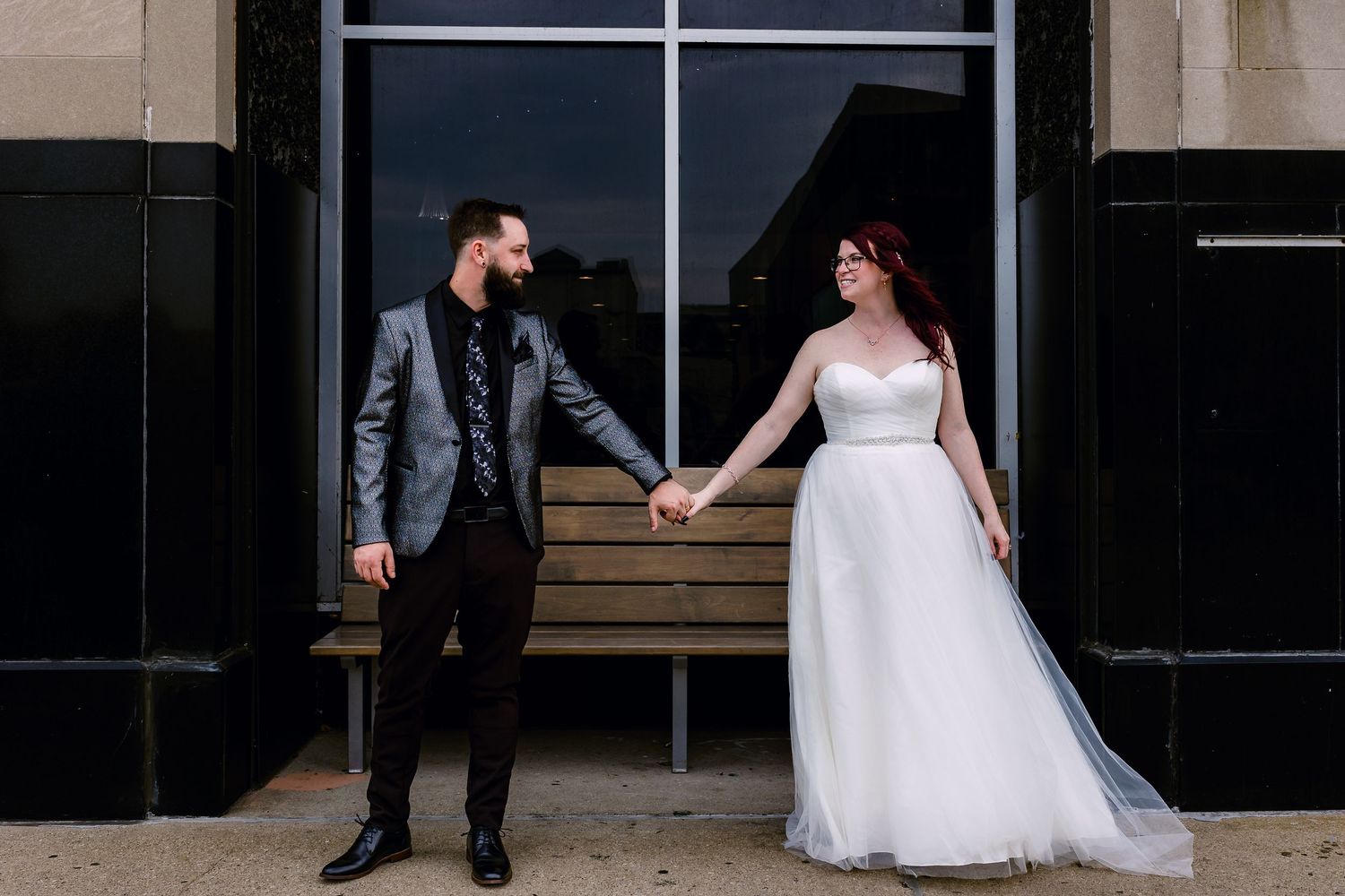 Bride and groom posing in front of their wedding venue in Kenosha, Wisconsin, showcasing the elegant setting.