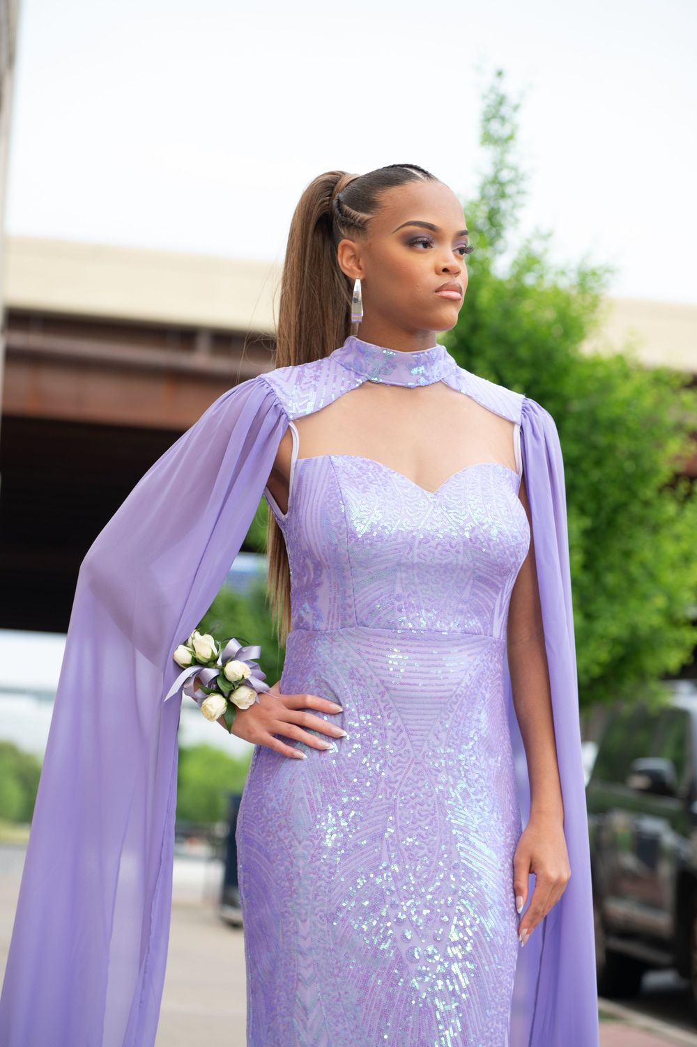 Lavender sequined gown with flowing cape details captured in outdoor setting.