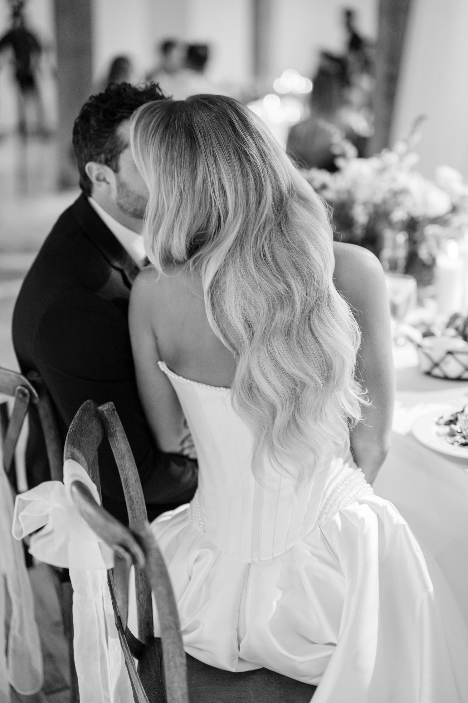 Black and white wedding photo showing bride with long wavy blonde hair sitting at reception table. - The Bridgeport Art Center Wedding