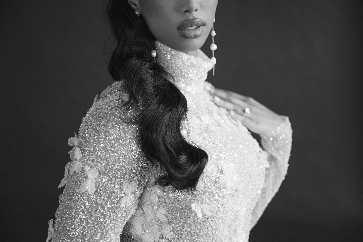 Elegant black and white portrait featuring intricate lace high-neck wedding dress with delicate beading details.