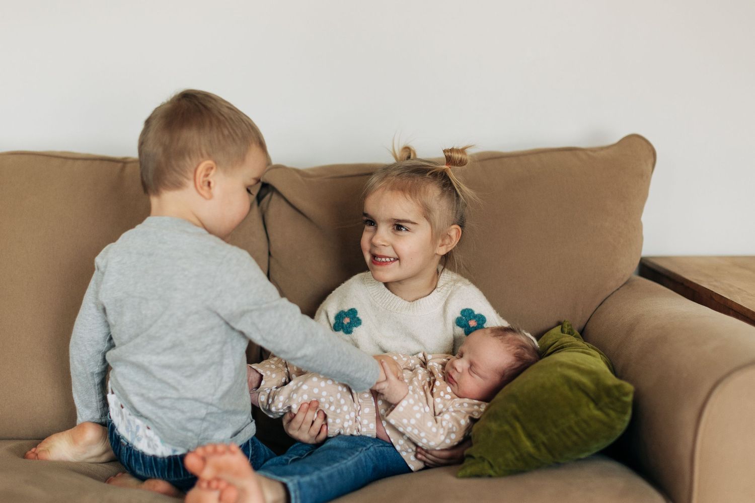 Young siblings share a sweet moment while sitting on their living room couch.