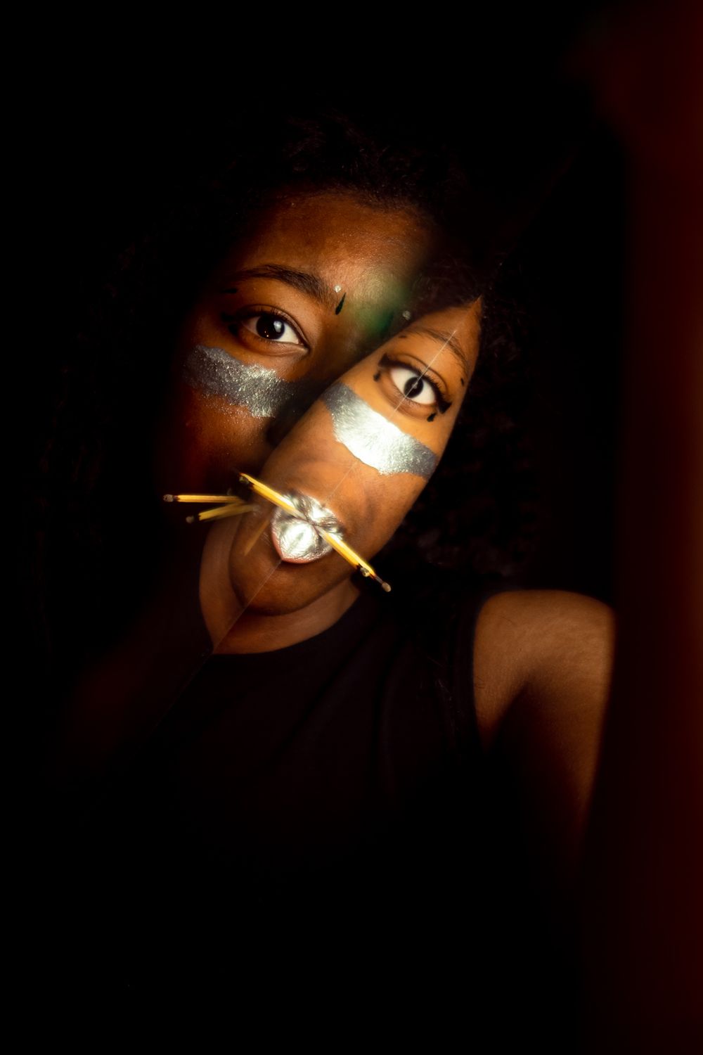 A person with matches in their mouth and a distortion on part of their face.