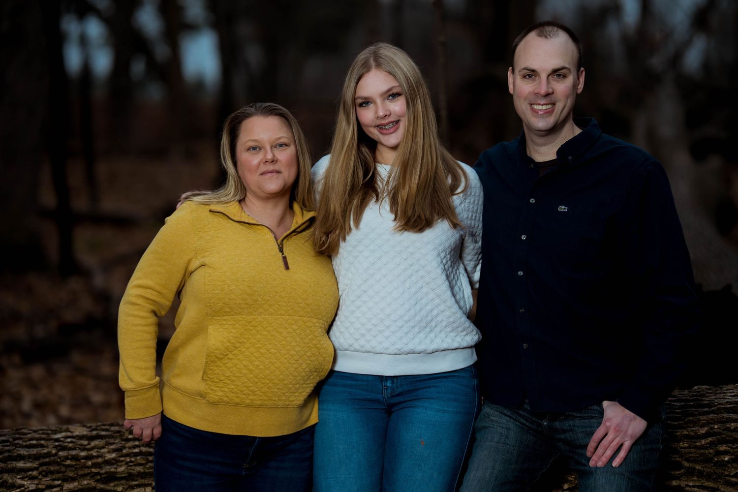 A happy family poses together, smiling for a group photo