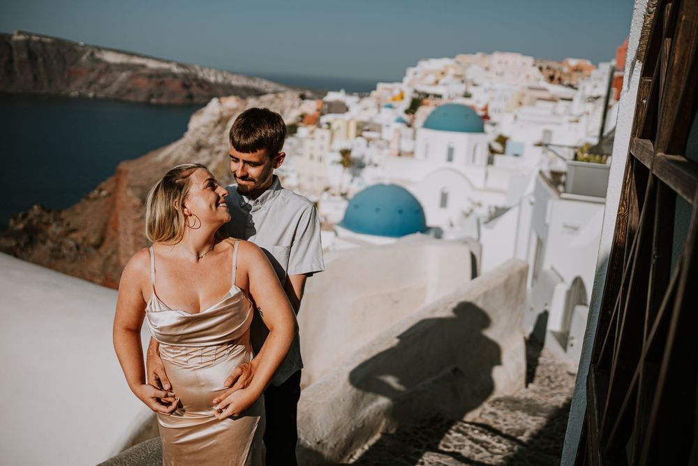 Golden hour photo overlooking iconic blue domes and white buildings of Santorini.