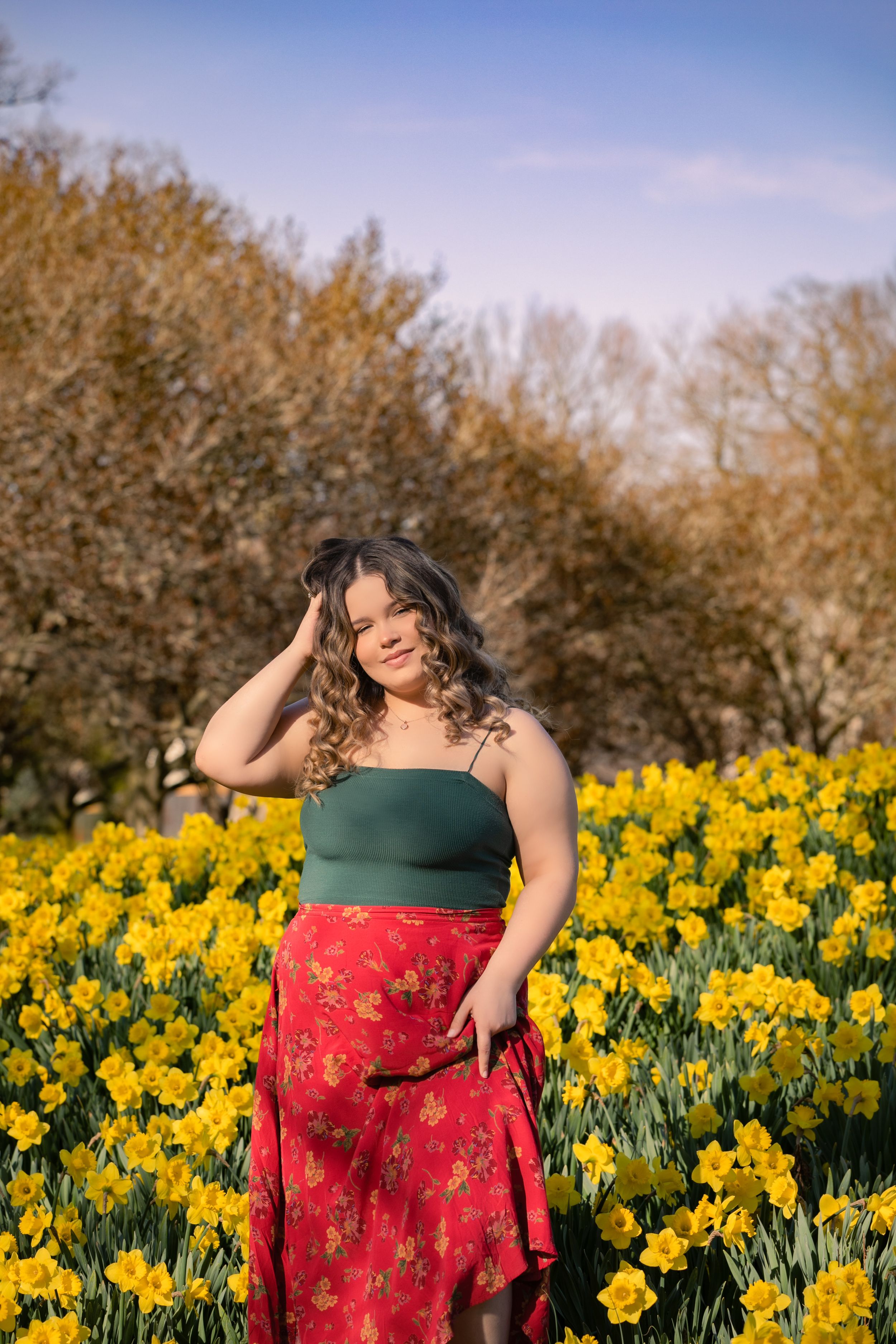Portrait session among bright yellow daffodils on a sunny day.
