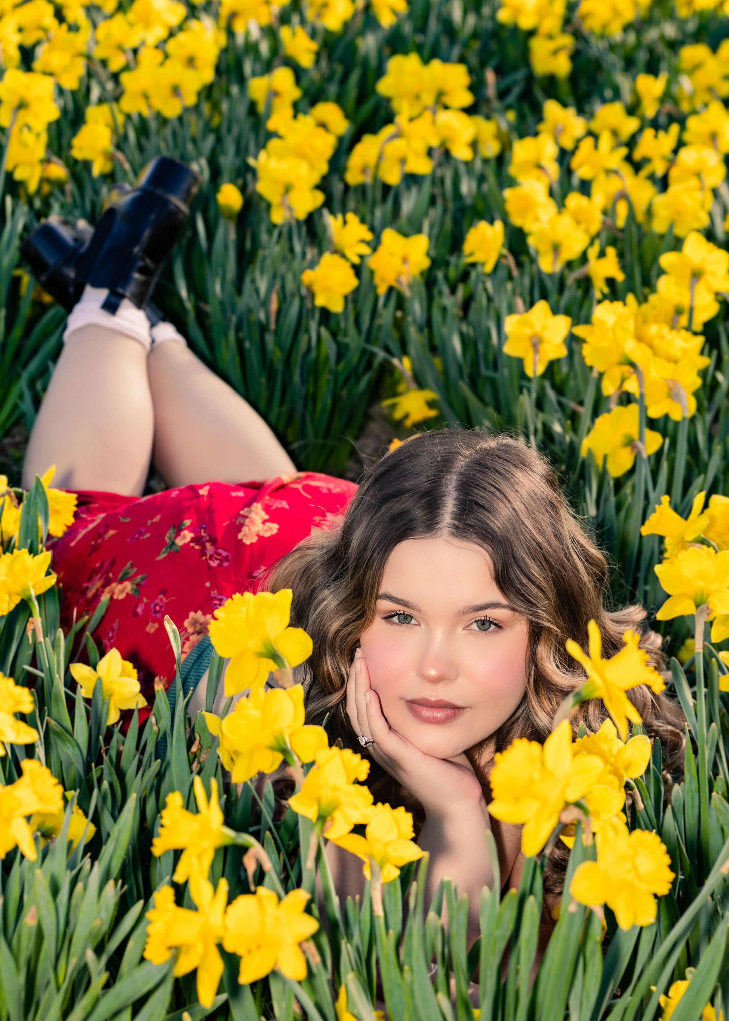 Creative portrait surrounded by vibrant yellow daffodils in full bloom.