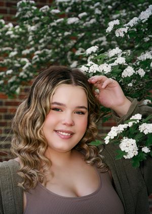 Spring portrait with delicate white flowering branches and natural curled hairstyling.